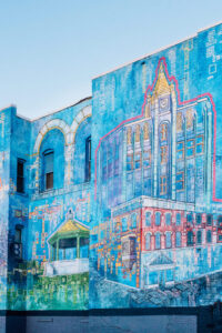 A mural of different buildings on the side of a building.